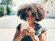 woman in sunglasses smiling at phone